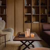 "Neutral tones with soft textures; warm wooden shelves and cozy, inviting furniture create a soothing atmosphere."