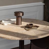 Round marble table with warm beige tones, bronze accents, and a sleek, modern design, perfect for contemporary decor.