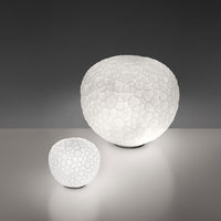 White textured lamps with a honeycomb pattern, featuring a smooth, round shape on a neutral background.