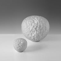 White textured spherical decor pieces in varying sizes with a unique bumpy pattern against a gray background.