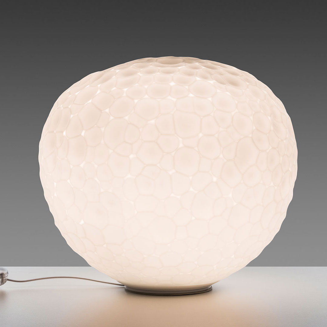 White honeycomb-patterned lamp with a soft glow, featuring a round, textured design against a gray background.