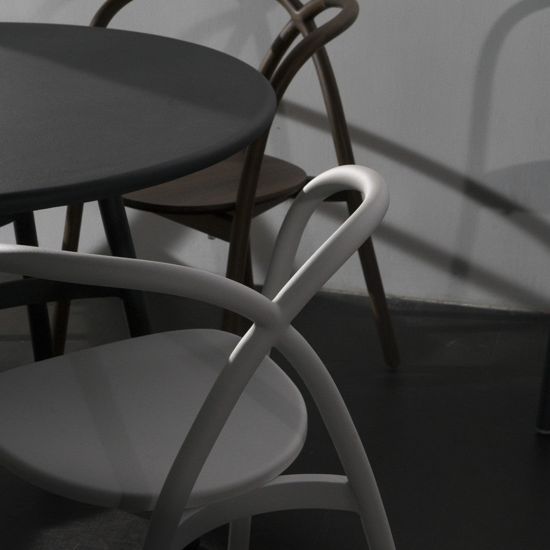 Gray, black, and brown furniture with minimalist design and smooth curves, highlighting elegant color contrast and shadows.