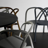 Set of modern chairs in black, gray, and brown, featuring sleek lines and unique shadow patterns on a minimalist background.