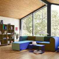Modern sectional sofa in green, blue, and purple hues, featuring a unique geometric design and vibrant color-blocking.