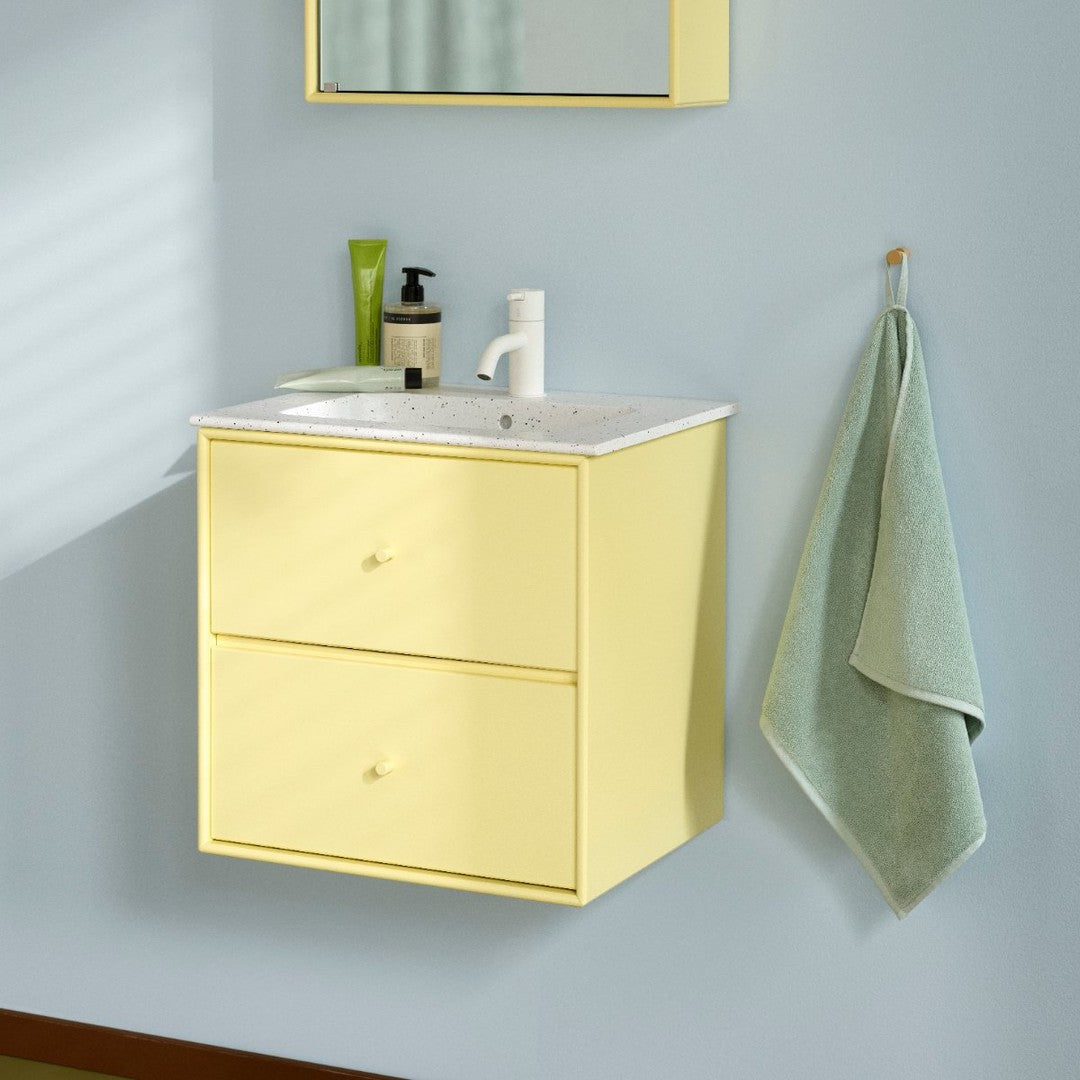 Yellow wall-mounted bathroom vanity with sleek design and white countertop, complemented by mint green towel and decor.