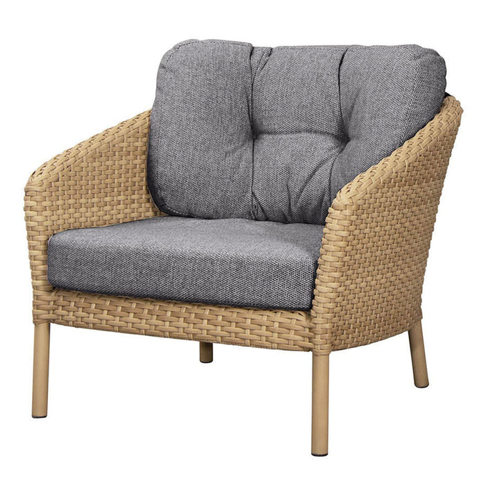 Gray upholstered chair with a woven rattan frame and light wood legs, featuring tufted cushions.
