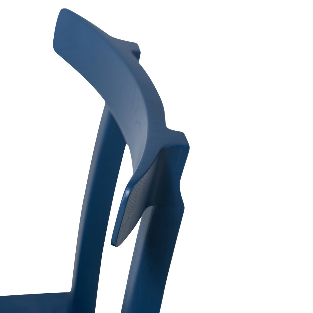 Modern blue chair with sleek design and smooth surfaces showcasing deep navy color and minimalist lines.