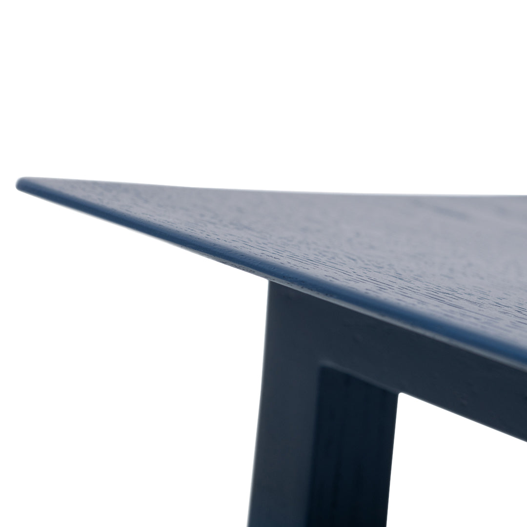 Navy blue table with a sleek, textured surface and sharp, modern angles.