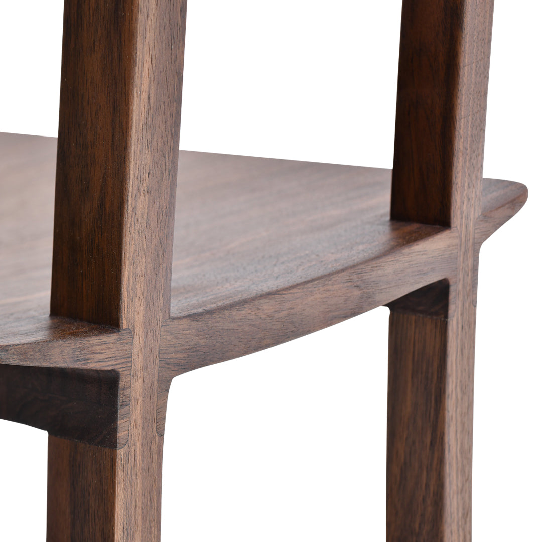 Close-up of a wooden chair in rich walnut color with smooth, sleek lines and subtle grain patterns.