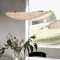 Elegant beige pendant light with smooth, curved design, complementing natural indoor decor.