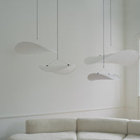 Modern white hanging light fixtures with sleek, curved shapes against a neutral background, enhancing minimalist decor.