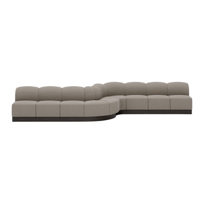 Modern sectional sofa in soft taupe upholstery with a smooth, curved silhouette and contrasting dark base.