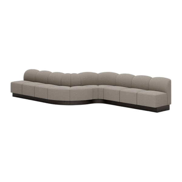 Beige curved sectional sofa with smooth, plush upholstery and a sleek black base. Modern and stylish design.