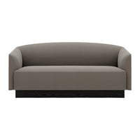 Gray upholstered sofa with a smooth, minimalist design and a sleek black base. Perfect for modern interiors.