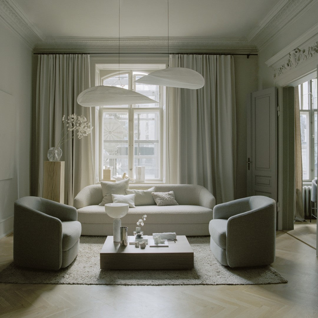 Modern living room featuring soft gray tones and elegant, minimalist patterns with neutral curtains and textured rug.