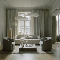 Modern living room featuring soft gray tones and elegant, minimalist patterns with neutral curtains and textured rug.