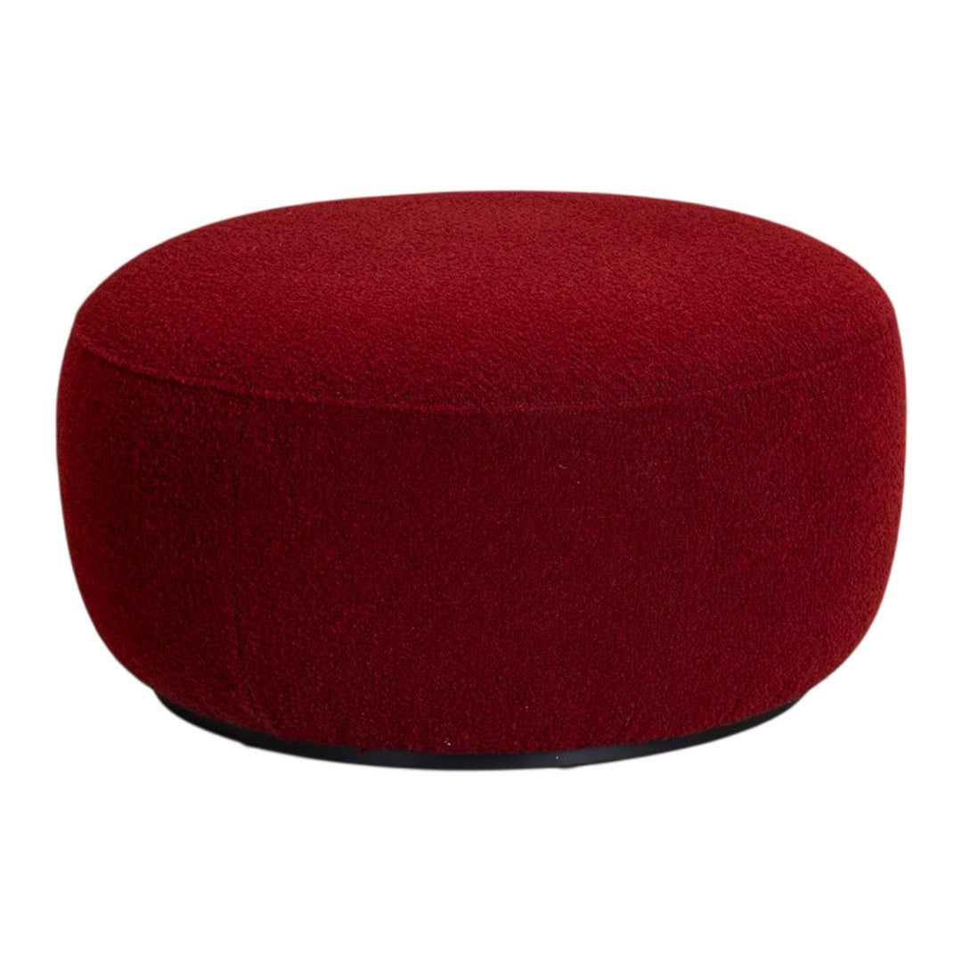 Round ottoman in rich burgundy upholstery with a textured finish, perfect for adding a pop of color to any space.
