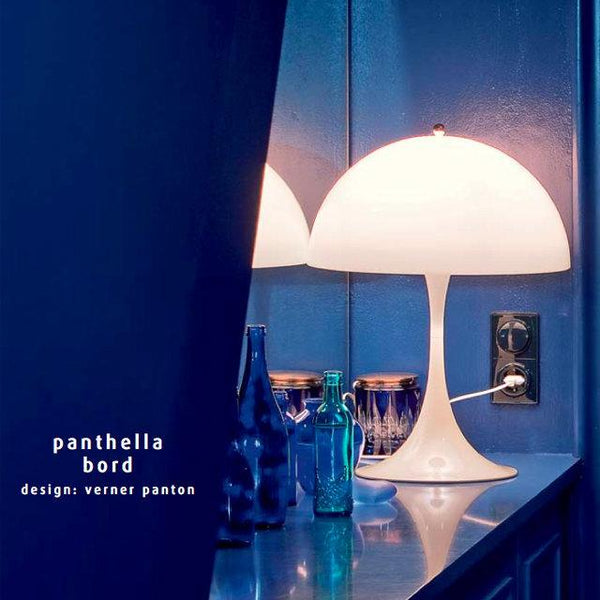 "Modern white lamp with a sleek, rounded base against a deep blue background, creating an elegant contrast."