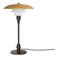 Modern table lamp featuring a glossy gold shade, frosted white layers, and a sleek dark bronze base.