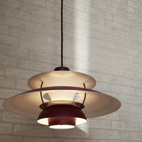 Modern pendant lamp featuring layered circular shades in warm red and soft white hues, against a textured gray background.