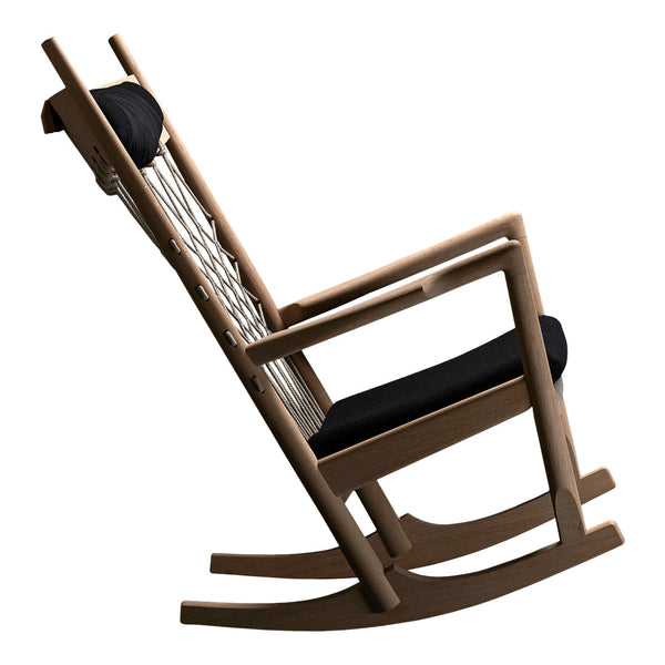 Black cushioned rocking chair with a natural wood frame and woven backrest, showcasing a modern and minimalist design.