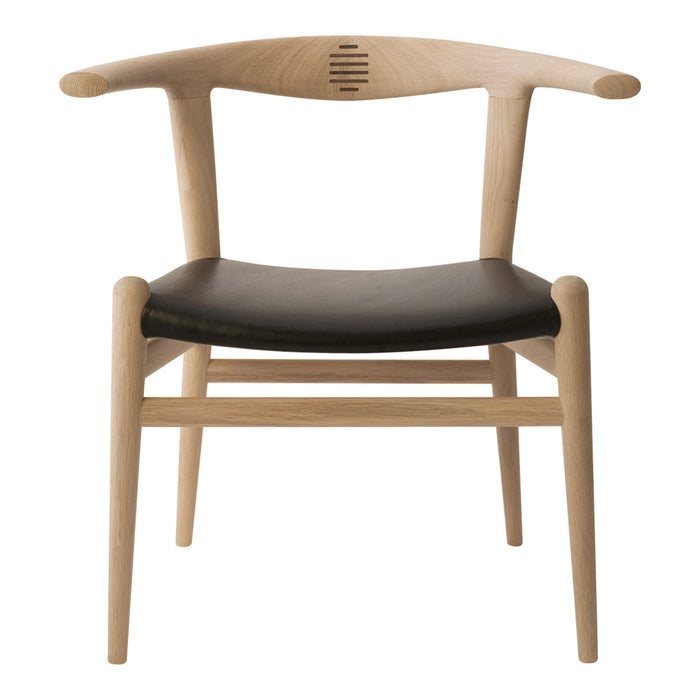 Natural wood chair with a light oak finish and a sleek black leather seat, featuring minimalistic design and subtle curves.
