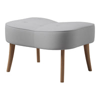 Light gray tufted ottoman with curved design and natural wood legs, perfect for modern decor.