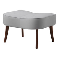 Soft gray upholstered ottoman with tufted design and dark wooden legs, featuring a modern, minimalistic shape.