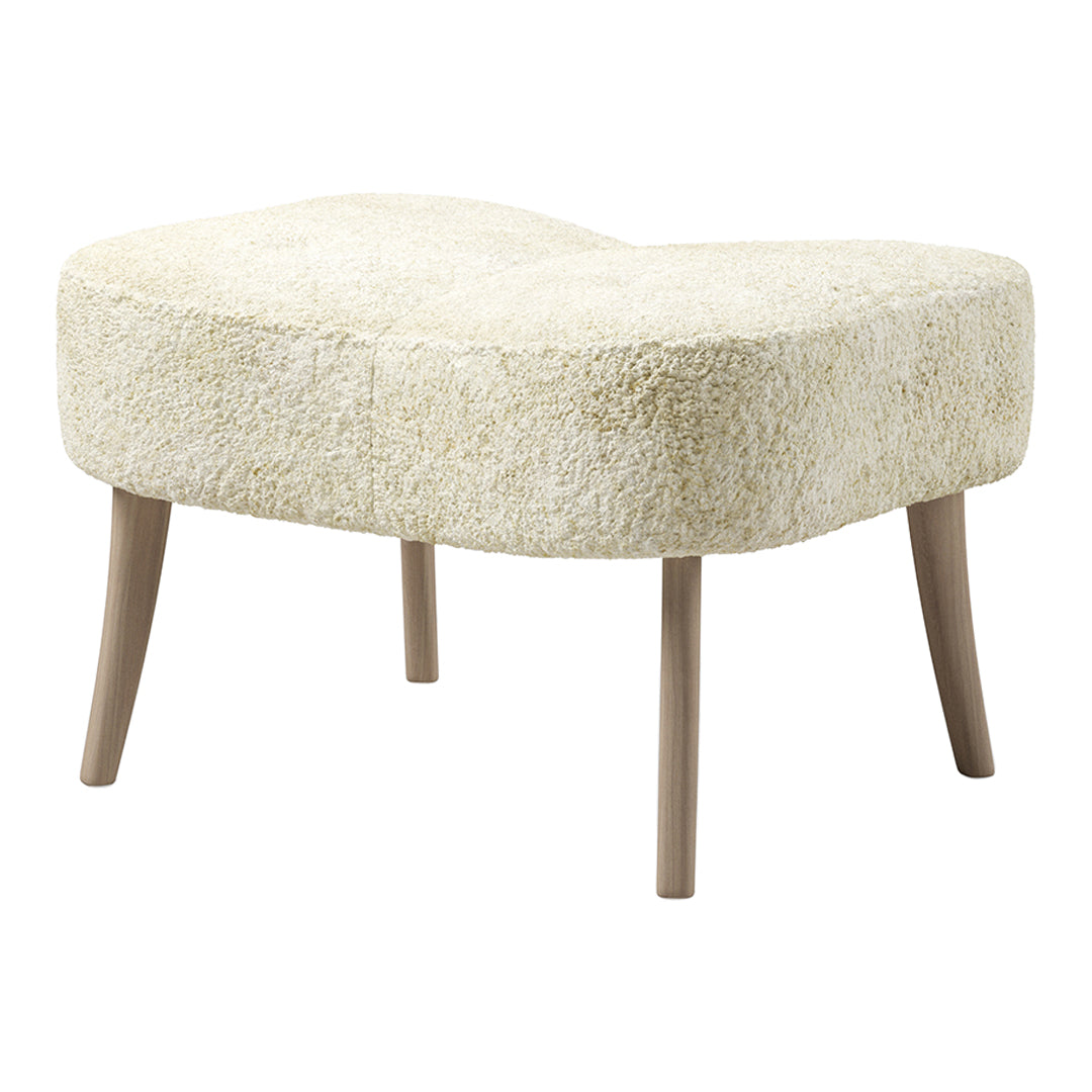 Creamy beige curved ottoman with a fluffy texture and light wooden legs, perfect for stylish interiors.