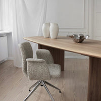 Light beige modern chairs on a wooden table, accented by white ceramic vases against a minimalist backdrop.