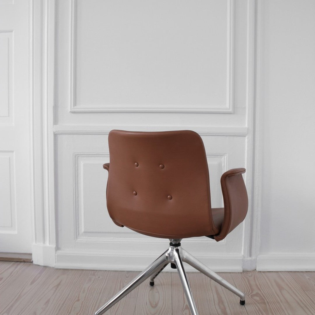 Brown leather swivel chair with button tufting, set against a clean, white wall backdrop.
