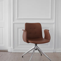 Brown leather chair with a smooth surface and button tufting, set against a minimalist white backdrop.