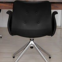 Black upholstered chair with button-tufted pattern and sleek silver base, perfect for modern office decor.
