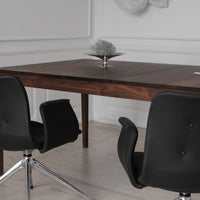 Elegant dark wood table with sleek black chairs, minimalistic design against a light, neutral backdrop.
