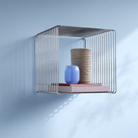 Modern wall shelf featuring sleek silver lines, pastel pink, light blue ceramic, and neutral tones. Ideal for contemporary decor.