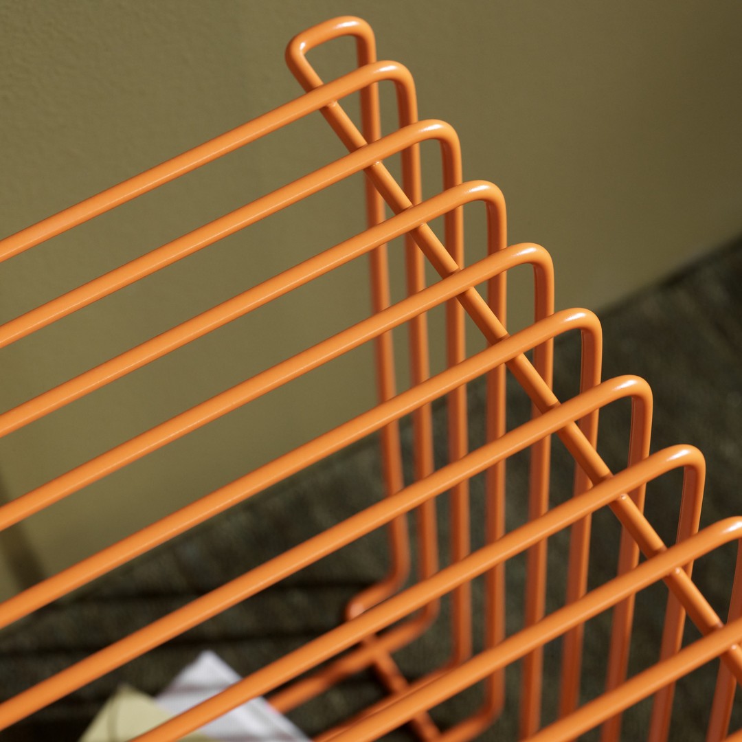 Orange metal wire rack with clean lines and geometric pattern against a neutral background. Perfect for modern decor.