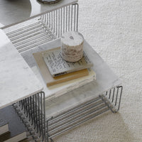 Modern marble coffee table with a sleek metal wire frame, featuring neutral tones and a minimalist design.