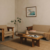 Beige upholstered furniture set with wooden accents, natural fiber rug, and a minimalist decor featuring earthy tones.