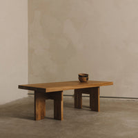Natural wood coffee table with a warm, honey-toned finish and a smooth, minimalistic design against a neutral backdrop.