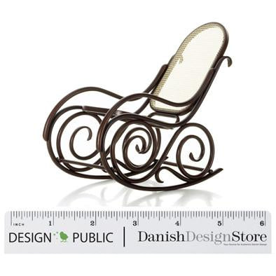 "Brown metal rocking chair with intricate scroll patterns and a cream seat cushion."