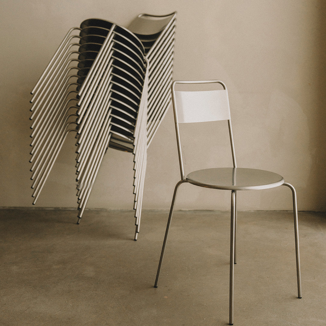 "Minimalist gray metal chair with a sleek white seat, featuring a modern stacked design."