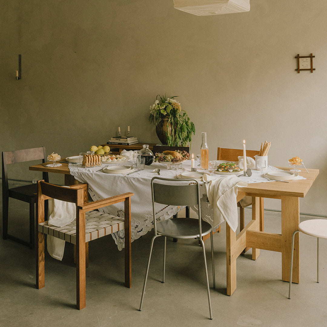 "Neutral tones with patterned chair cushions and a crisp white tablecloth on a modern dining table setup."