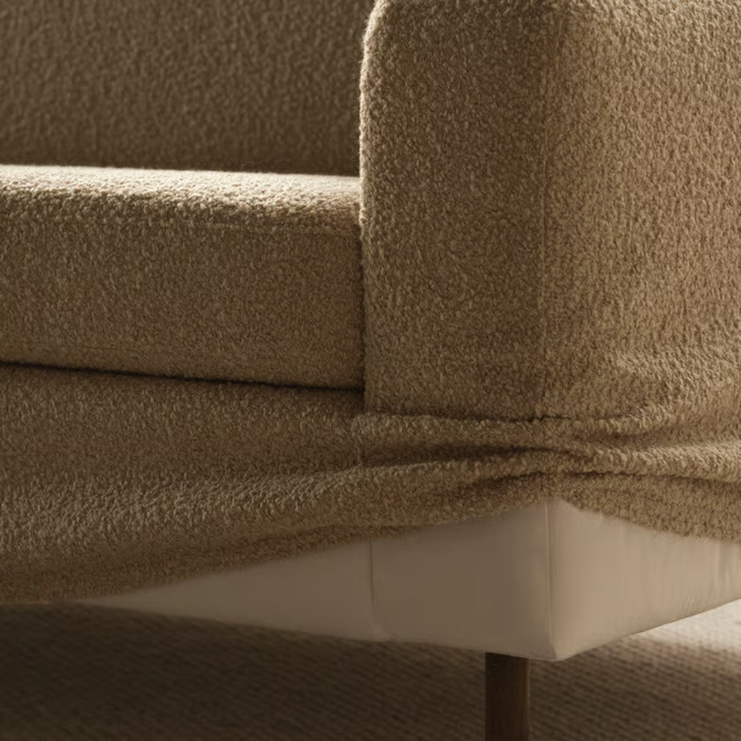 Textured beige upholstery on a modern sofa, featuring soft, cozy patterns and sleek lines. Perfect for any living space.