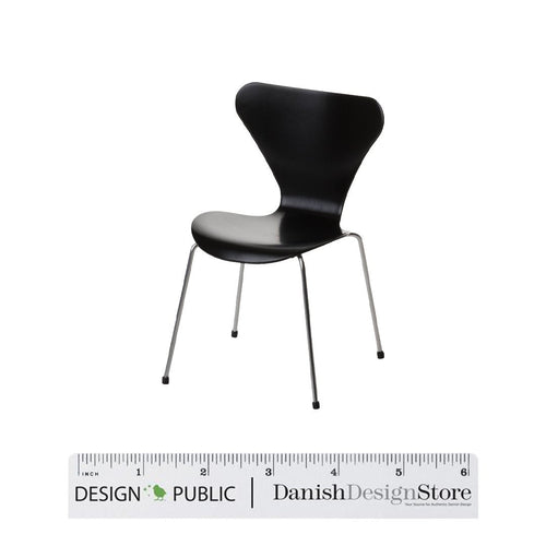Black chair with a sleek, modern design and smooth surface, supported by slender metal legs.
