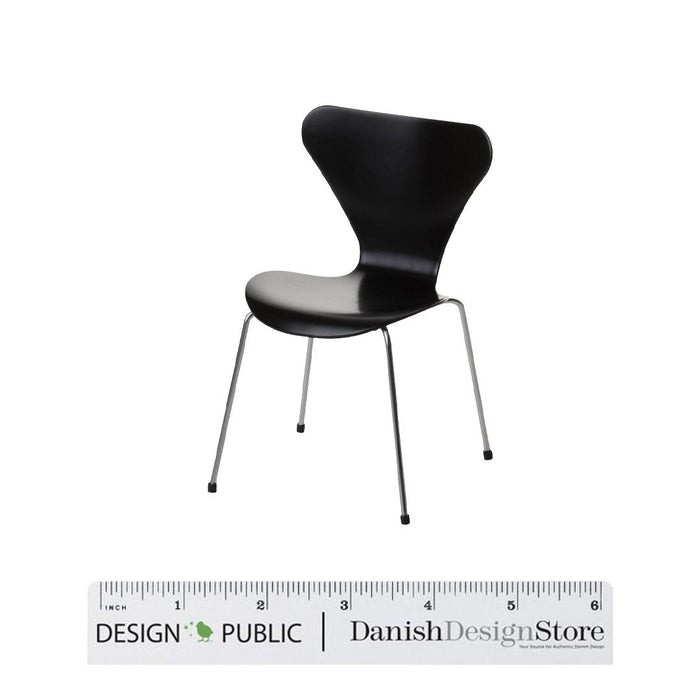 Black chair with a sleek, modern design and smooth surface, supported by slender metal legs.