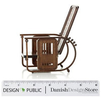 "Vintage brown metal rocking chair with intricate cutout patterns and a sleek modern design."