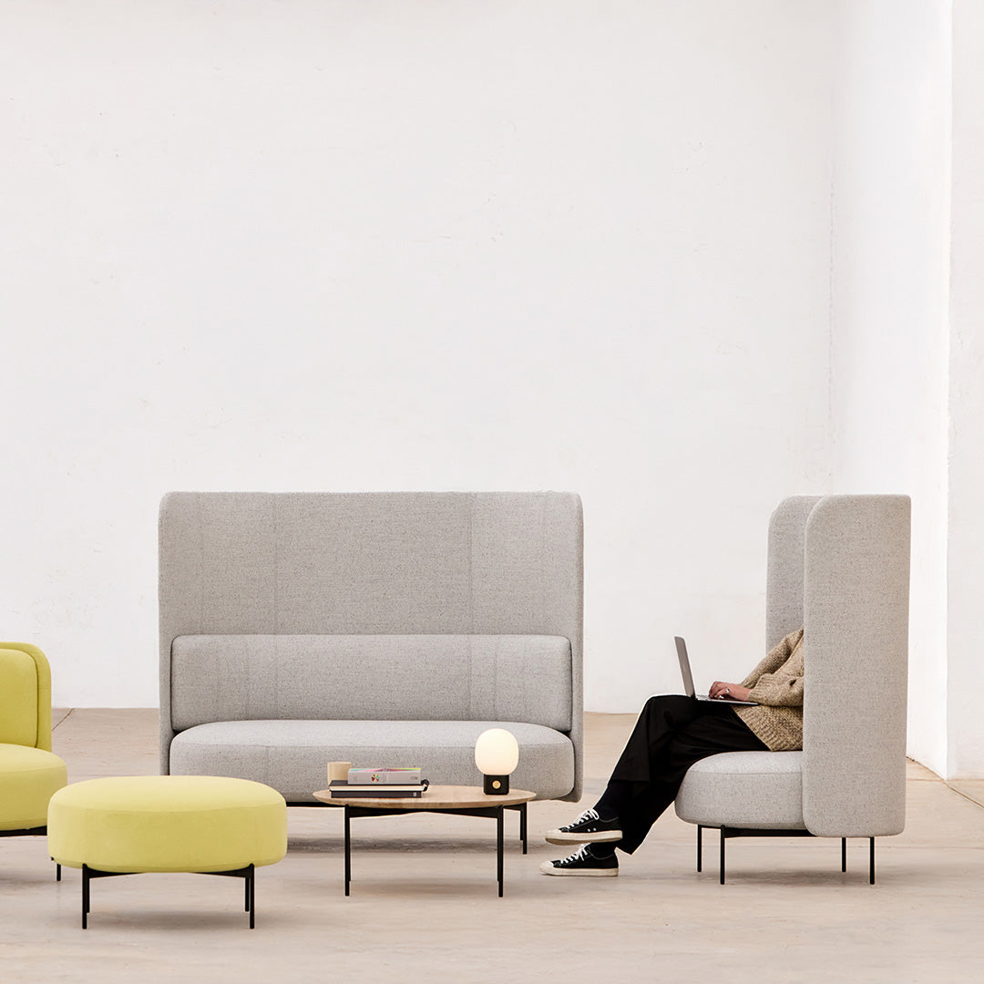 Gray upholstered seating with a textured finish, paired with bright yellow accents and minimalist black legs.