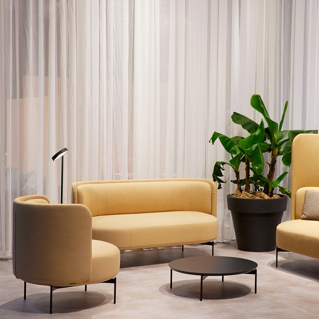 Soft yellow seating paired with sleek black accents, featuring a modern design in a light, airy setting.