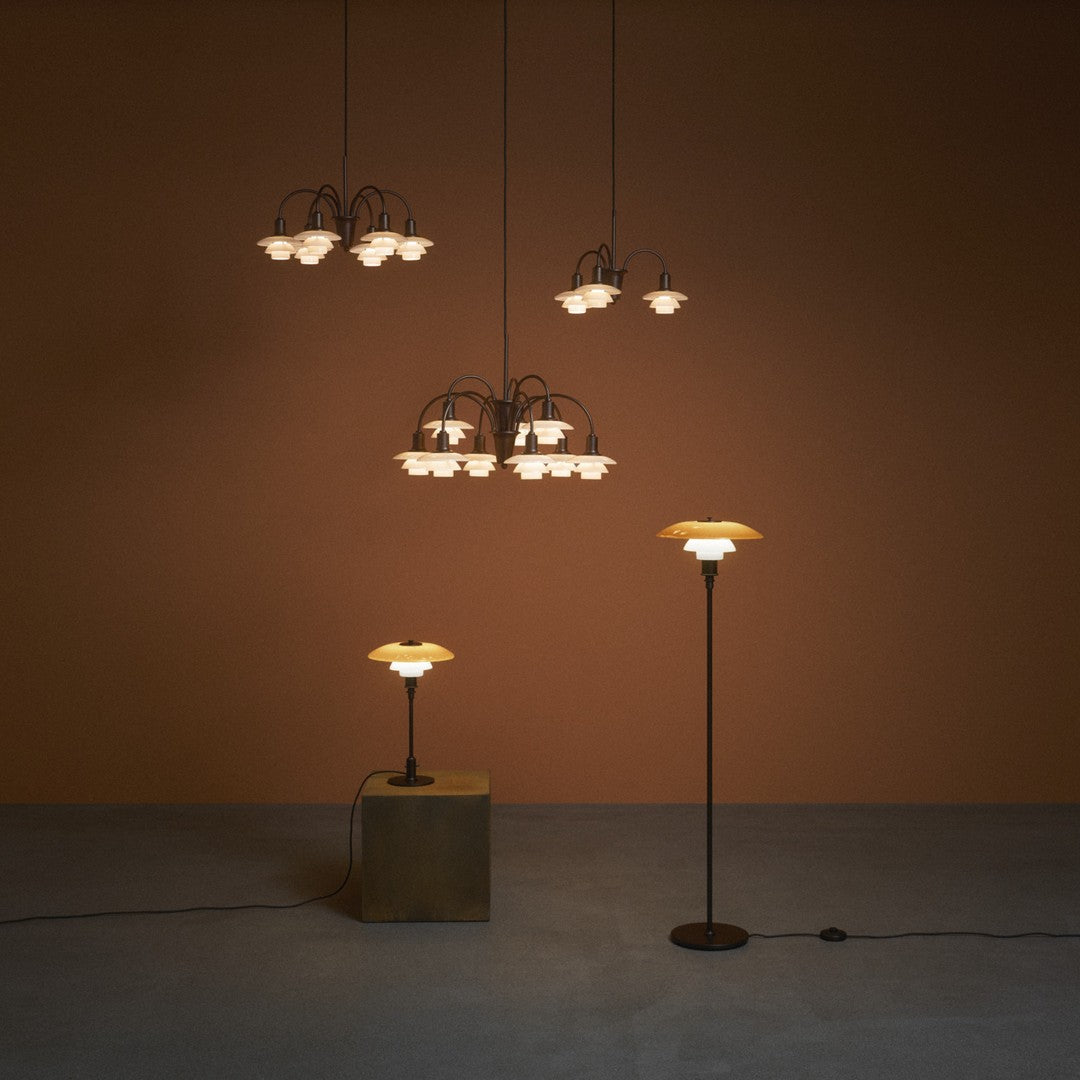 Modern pendant and floor lamps with warm white glass shades against a textured brown backdrop. Elegant and stylish design.