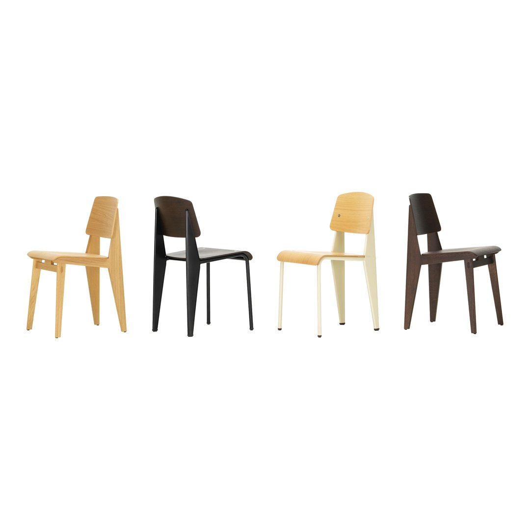 Four chairs in varied colors: natural wood, black, cream, and dark brown, featuring simple, modern designs.